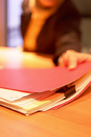 Person reaching for red file folder